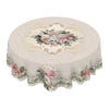 Vintage floral tablecloth featuring a delicate pink and green rose and daisy print on a cream fabric.