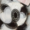 A collection of black and white lace stickers and die-cut shapes for crafting projects.