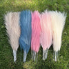 Un ramo de plumas de pampas artificiales en varios tonos de azul, rosa y blanco.