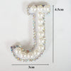 White alphabet letter T made of pearls and rhinestones, measuring 4.5cm high and 3cm wide.