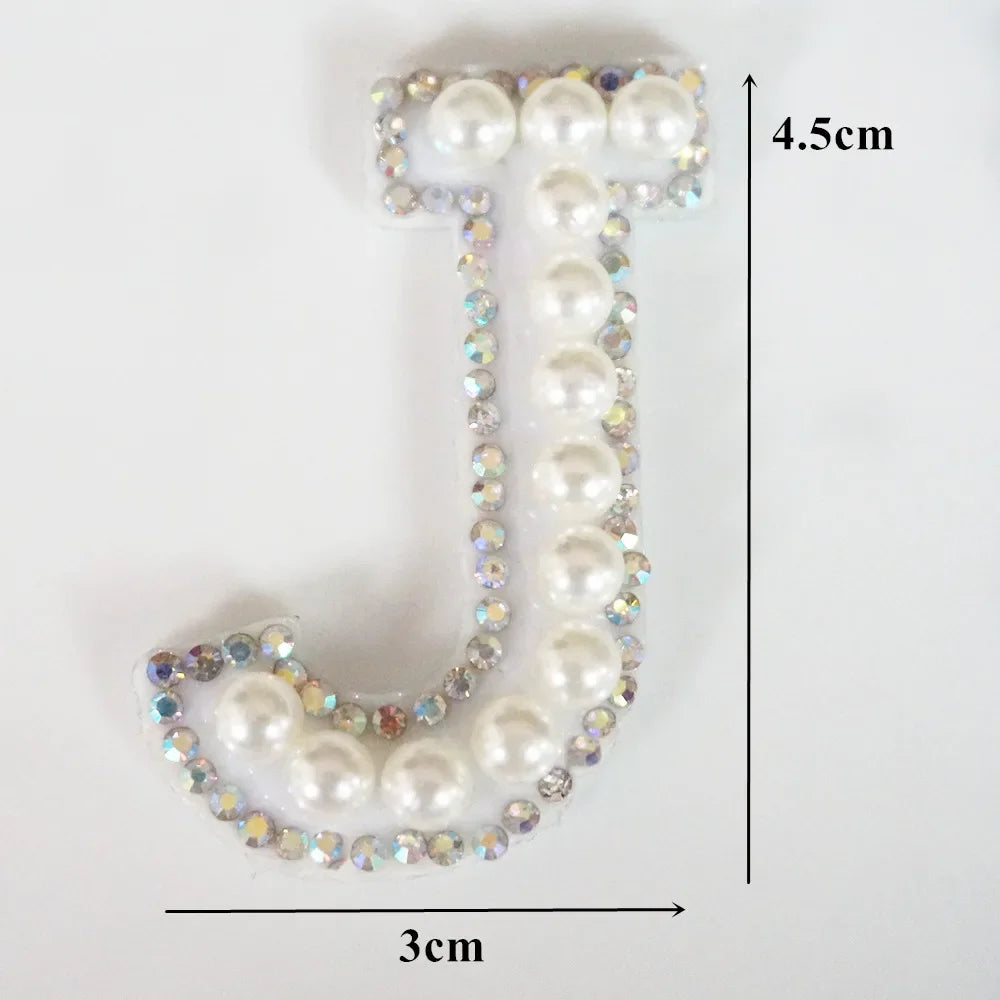 White alphabet letter T made of pearls and rhinestones, measuring 4.5cm high and 3cm wide.