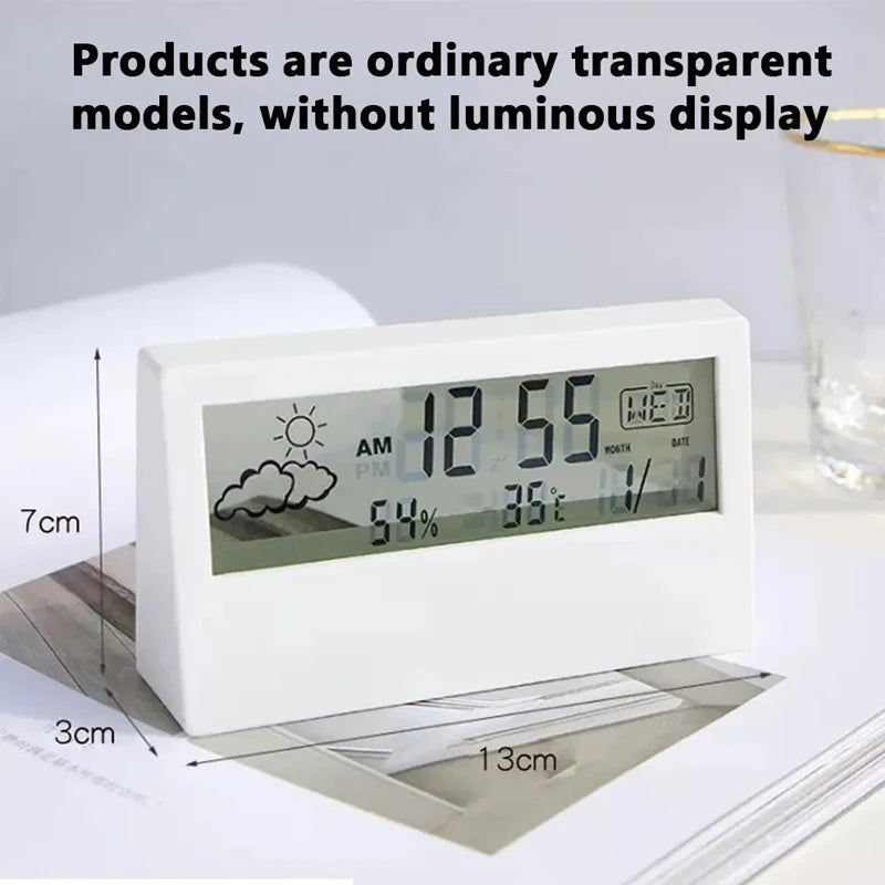 A white LED digital thermometer and hygrometer displaying 12:55 AM, 54% humidity, and 36°C, resting on a document.