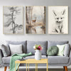 A gallery wall featuring three framed canvas prints of forest animals, including a deer and a fox, displayed above a gray sof