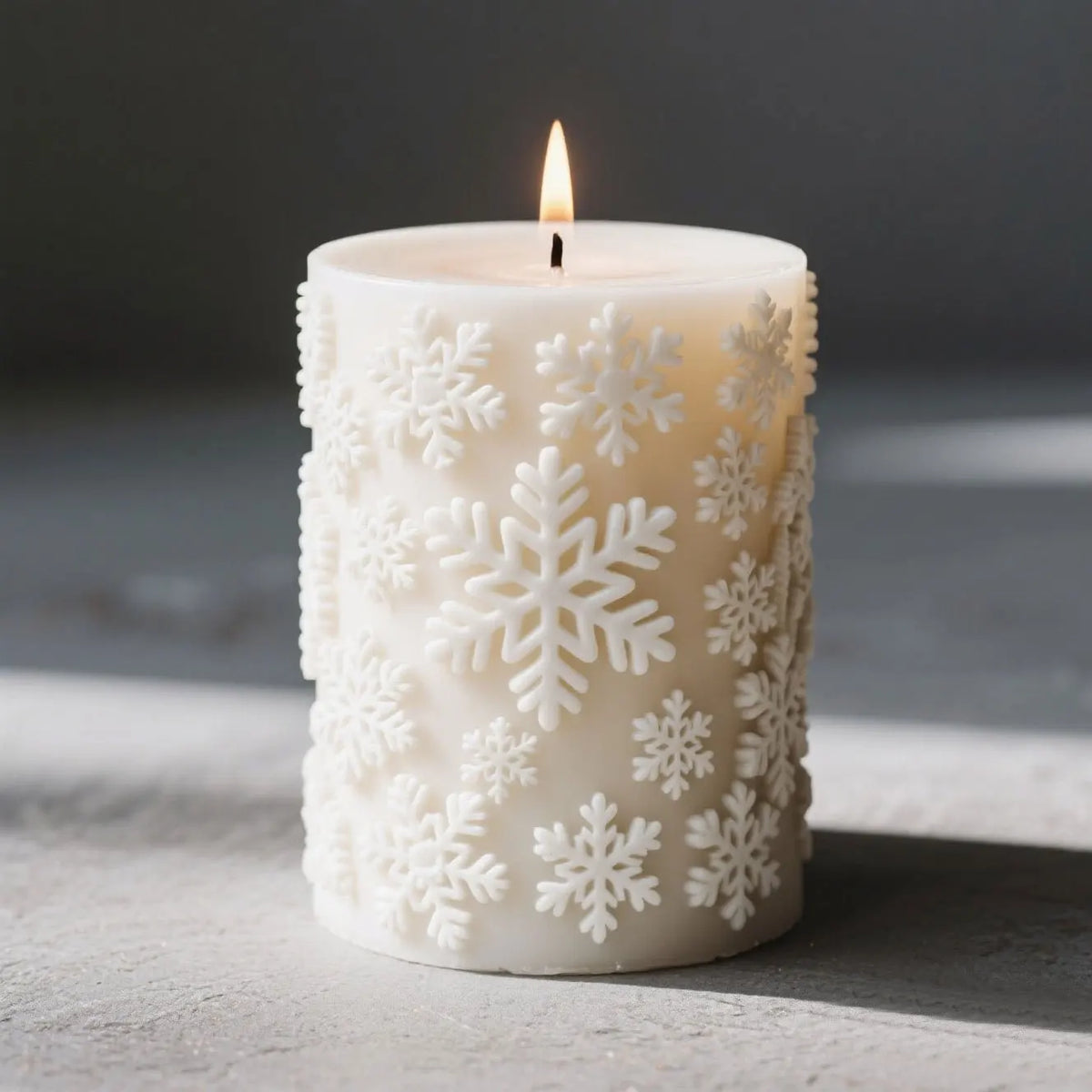 White candle in a cylindrical holder decorated with carved snowflake patterns