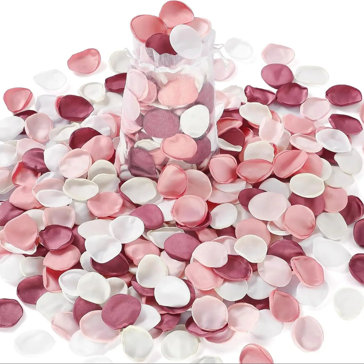 Una colección de pétalos artificiales de seda rosa y blanco en varios tonos esparcidos sobre un fondo blanco.