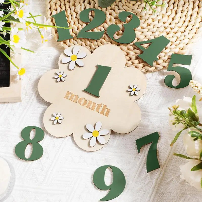 Wooden monthly milestone cards showing numbers 1 through 9 cut from green and natural wood on a white background