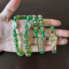 Green crystal rosary necklace featuring Saint Jude and Virgin Mary beads and a gold cross pendant