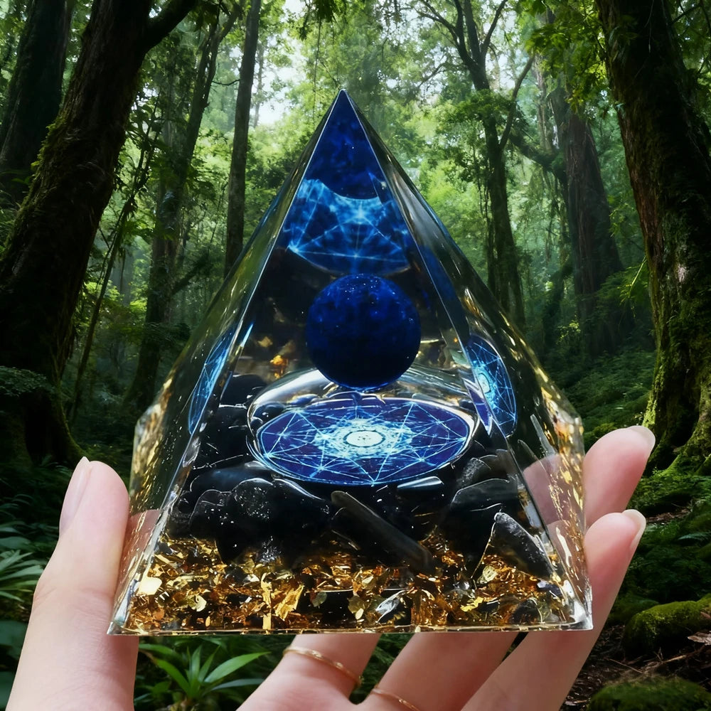 Handmade resin orgonite pyramid with natural obsidian and copper coil held against a forest background