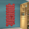 A vertical display of red hexagon stickers with the text Tina home lifestyle store on a teal wall next to a wooden cabinet.