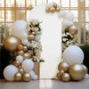 A white arch backdrop decorated with gold and white balloons in a bright indoor setting.