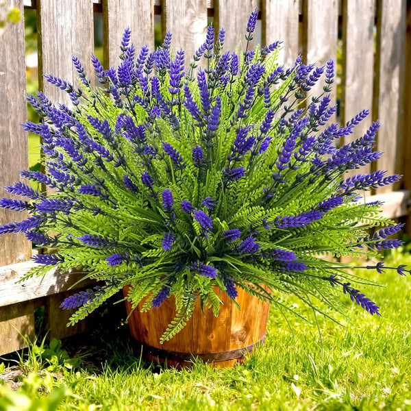 A vibrant bouquet of artificial purple lavender flowers in a wooden pot set against a green lawn.