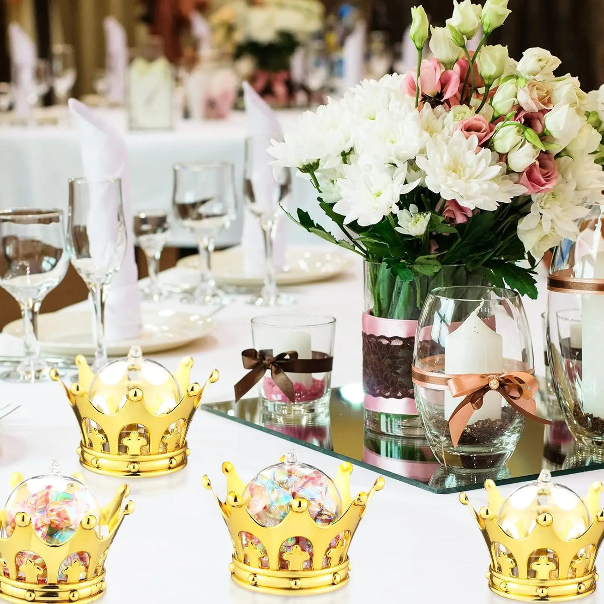 A collection of gold crown-shaped candy boxes displayed on a white table.