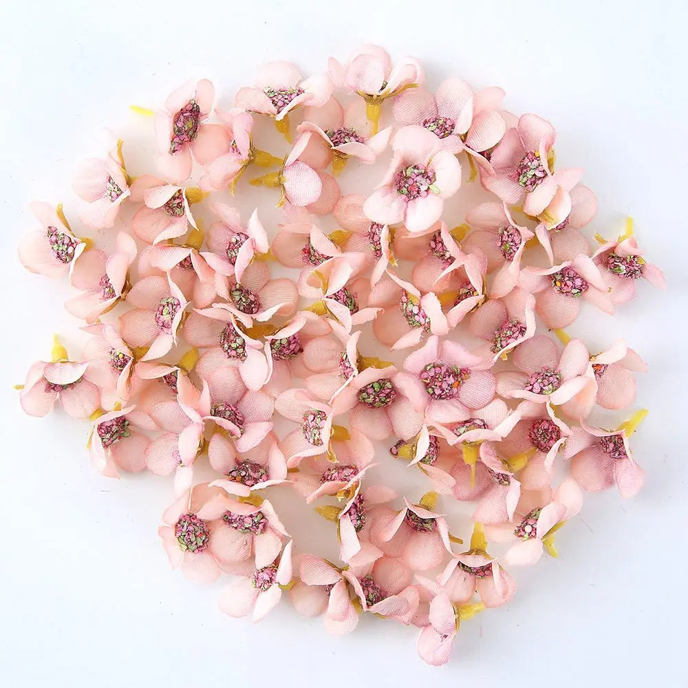 A loose arrangement of pink and white silk artificial flower heads for weddings, crafts, and home decor.