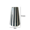 A tall ceramic vase with vertical black and white stripes, shown from the side.