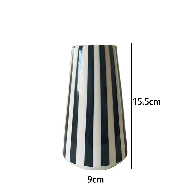 A tall ceramic vase with vertical black and white stripes, shown from the side.