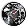 A black wall clock face featuring a design of jazz music notes and silhouettes of musical instruments.