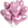 A bunch of ten shiny pink heart-shaped foil balloons tied together.