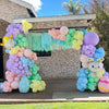 A colorful archway made of pastel rainbow latex balloons for party décor