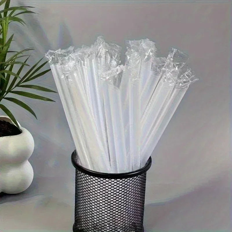 A bundle of clear disposable plastic straws stored in a black mesh container.