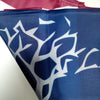 A close-up of a navy blue fabric banner featuring white stylized tree or mound patterns.