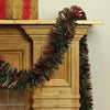 A festive Christmas tinsel garland with red and green strands draped over a wooden mantelpiece.