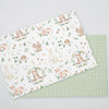 A fabric featuring an animal paradise floral print with bears, rabbits, and deer on a white background.