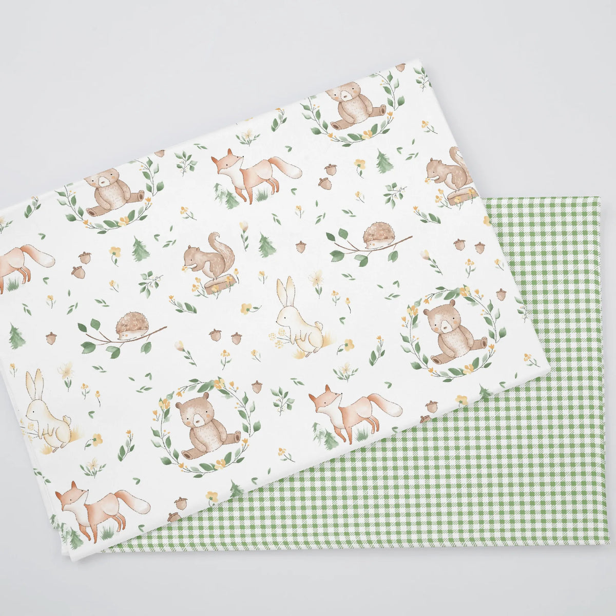 A fabric featuring an animal paradise floral print with bears, rabbits, and deer on a white background.