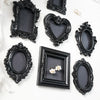 A collection of black ornate picture frames and decorative mirrors with gold accents on a white background.
