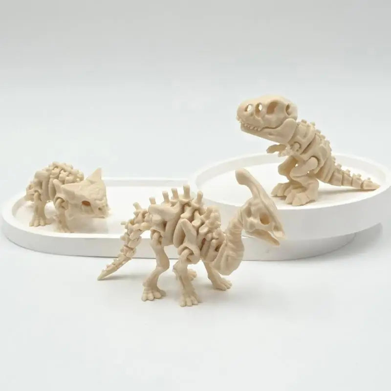 A set of 3D printed dinosaur skeletons displayed on a white background.