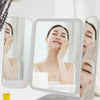 A tri-fold LED makeup mirror with dimmable lighting showing a woman's face for close-up application.