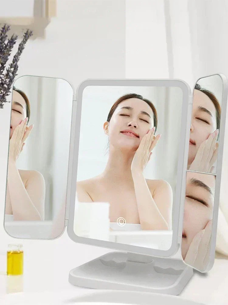 A tri-fold LED makeup mirror with dimmable lighting showing a woman's face for close-up application.