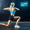 A woman in a blue sports top and black shorts is performing a lunge exercise in front of a dark wall with a neon sign that re