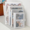 A stack of clear photo albums with transparent card holders displaying various portraits.