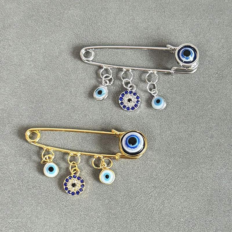 Elegant gold and silver evil eye brooch pin featuring multiple eye charms.