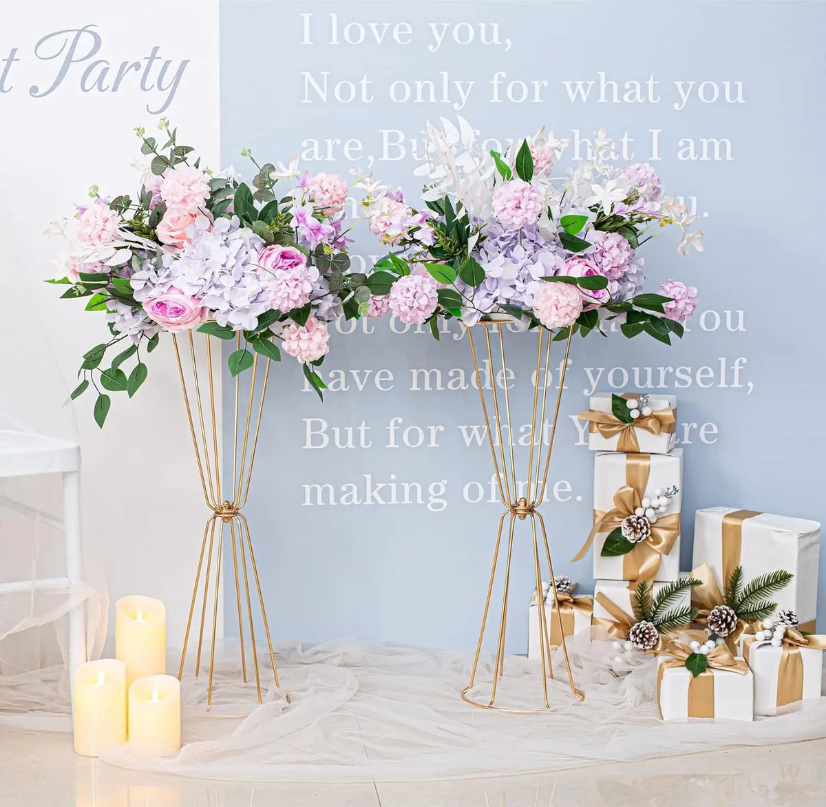 Gold geometric flower stands with pink and purple flowers decorating a table.