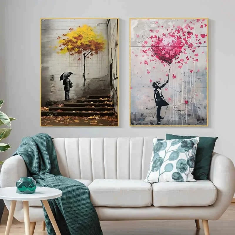 Two framed canvas prints featuring Banksy style imagery of a girl with balloons against a cityscape and pink floral backgroun