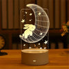 A glowing acrylic night light shaped like a crescent moon with a rabbit silhouette and stars on a wooden surface.