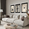 A modern living room features a light sofa and decorative pillows with framed art prints on the wall.