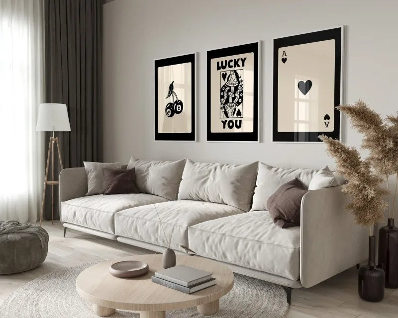 A modern living room features a light sofa and decorative pillows with framed art prints on the wall.