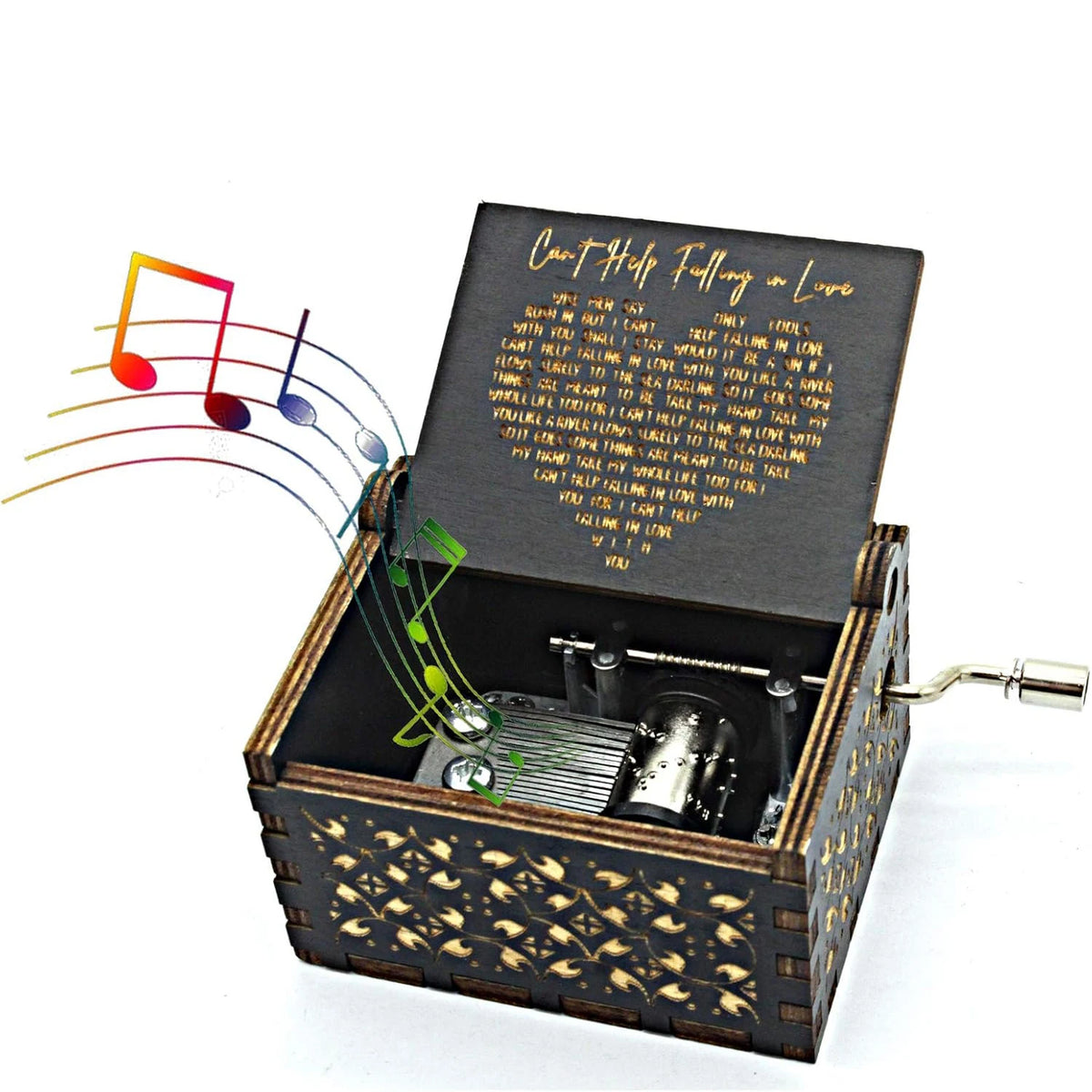A hand-cranked wooden music box with an antique engraved design and sheet music inside.