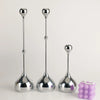 A set of three silver waterdrop design candle holders with elongated stems and rounded bases.