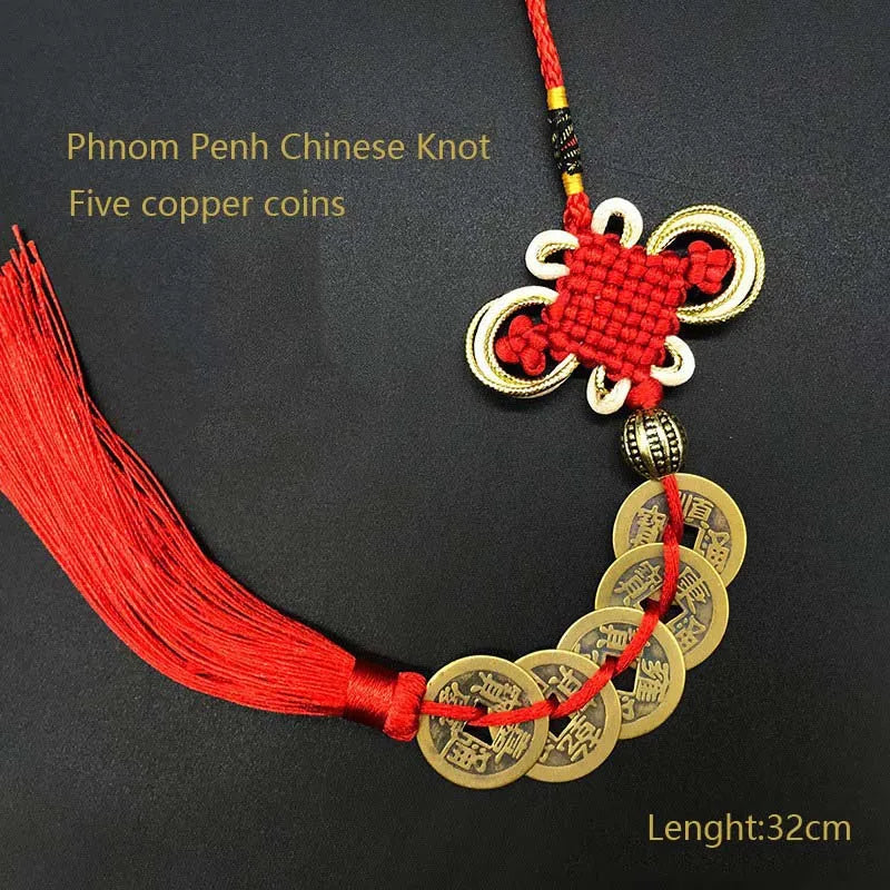 A red thread necklace featuring five antique copper coins tied in a Chinese knot.