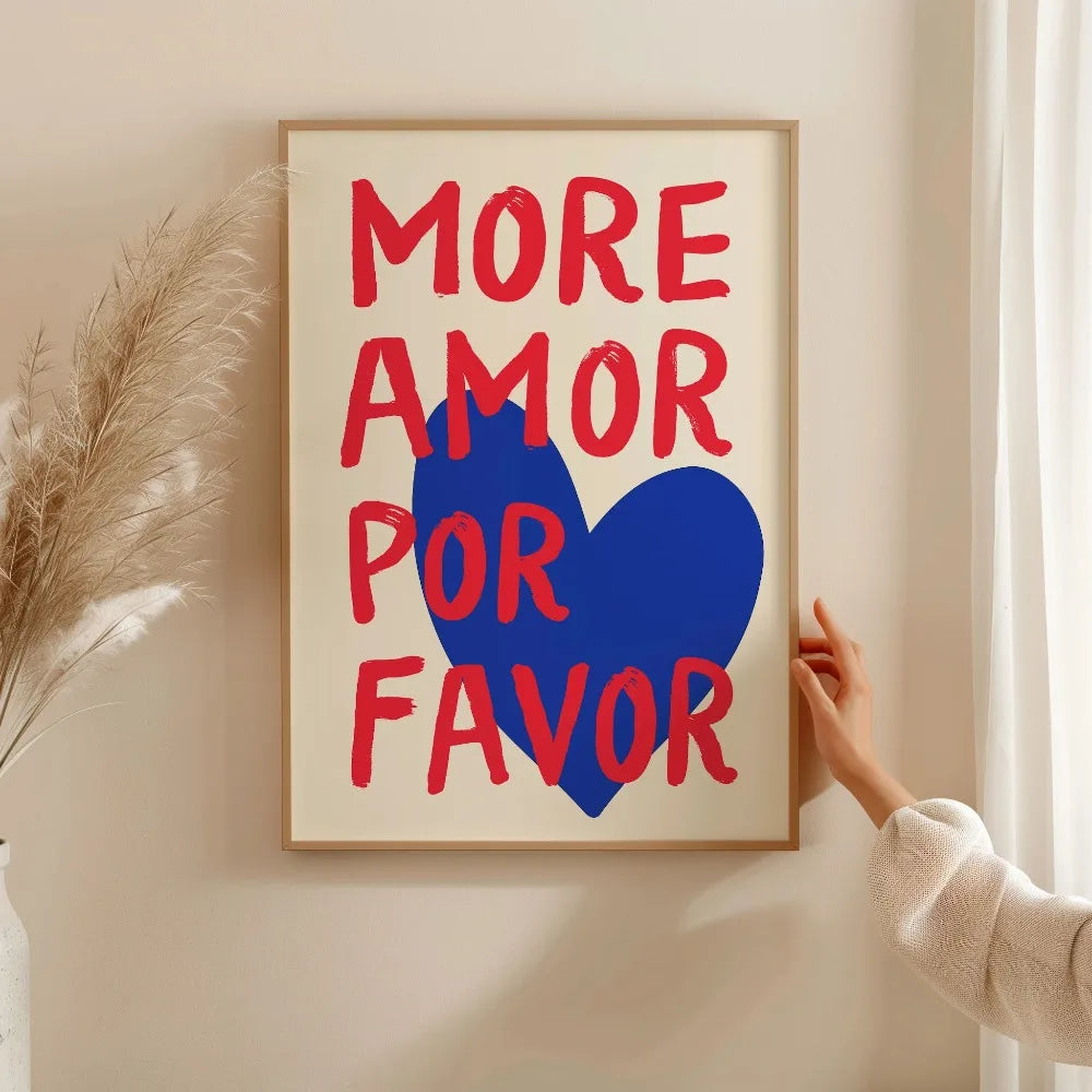 A framed canvas print featuring the text MORE AMOR FOR FAVOR in red and blue on a light background.