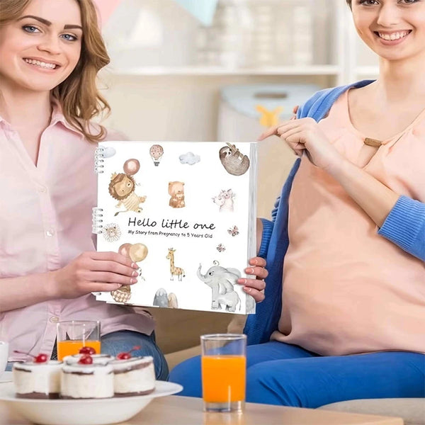A woman holds a pregnancy and baby memory journal organizer with illustrations of baby items.