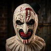 A close-up of a horror clown mask costume with white face paint, red streaks, and a black top hat.