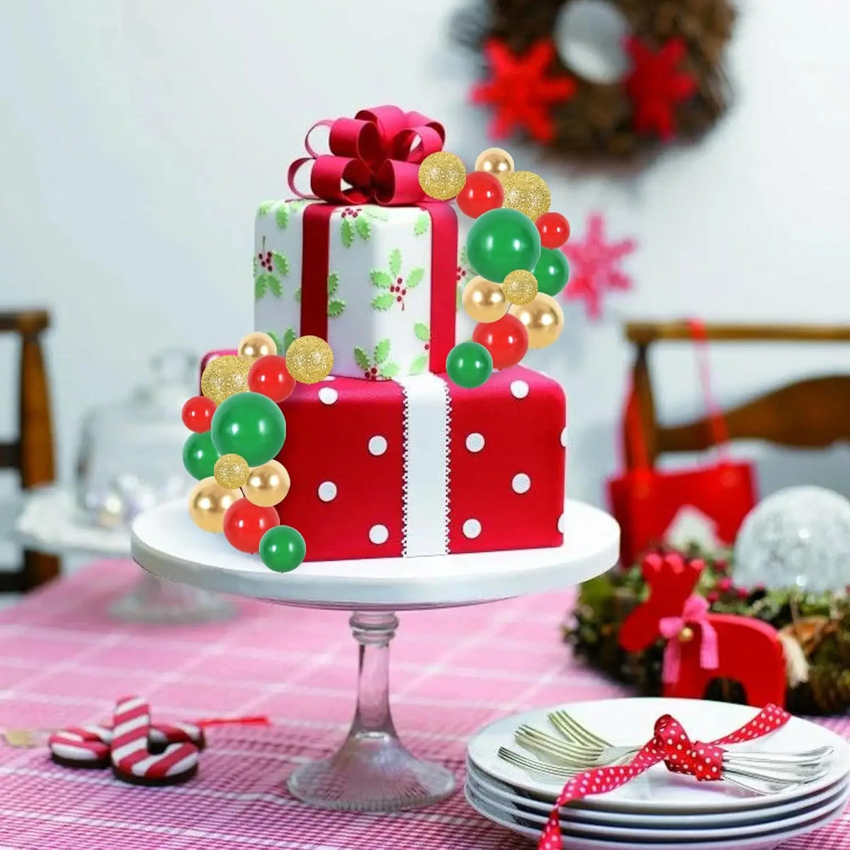 A tiered cake display featuring red and green foam ball toppers on a white stand.