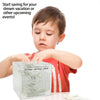 A young boy is looking at a clear acrylic piggy bank labeled with a 365-day savings plan.