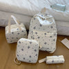 A white backpack set featuring a bow print pattern and matching accessories resting on a light-colored surface.