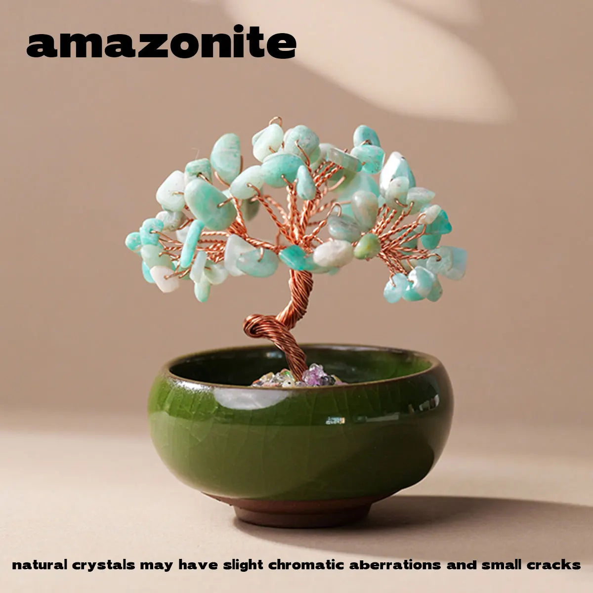 A handcrafted crystal tree with light blue and white crystals mounted on a copper wire base inside a green bowl.