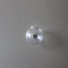 A clear glass spherical fridge magnet with a silver stud in the center.